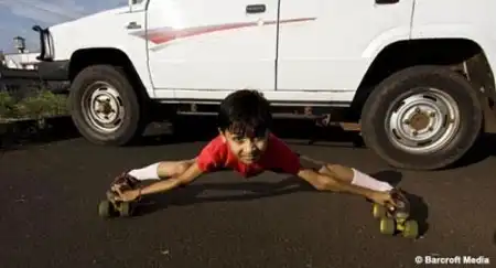 Гуттаперчивый мальчик проезжает под автомобилем.