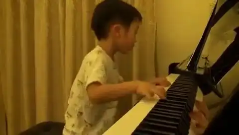 Четырехлетний мальчик играет на фортепиано