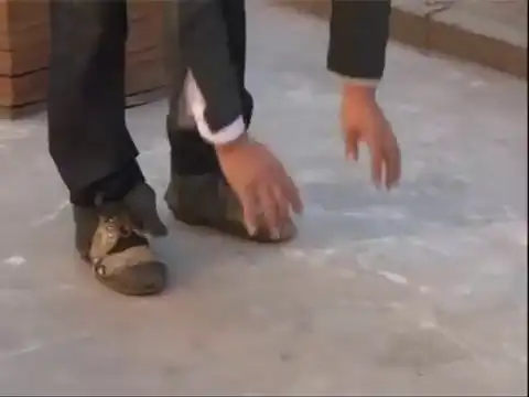 Китайский мужчина ходит по улице в 400-килограммовой обуви
