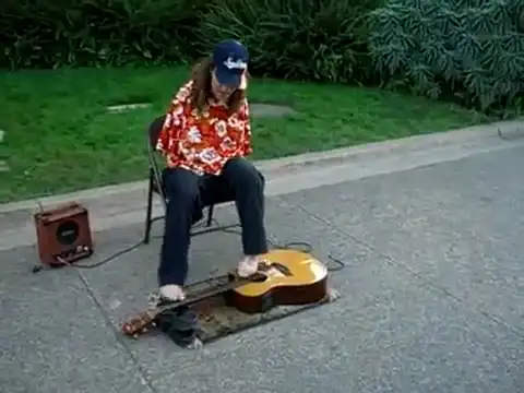 Музыкант-инвалид играет на гитаре пальцами ног