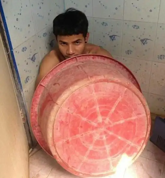 В Таиланде преступник пытался спрятаться от полиции под тазиком