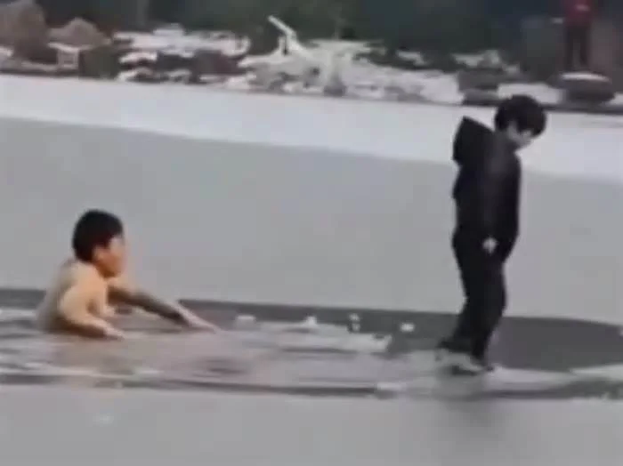 Добрый китаец вытаскивает ребенка из полыньи, но самостоятельно выбраться не может